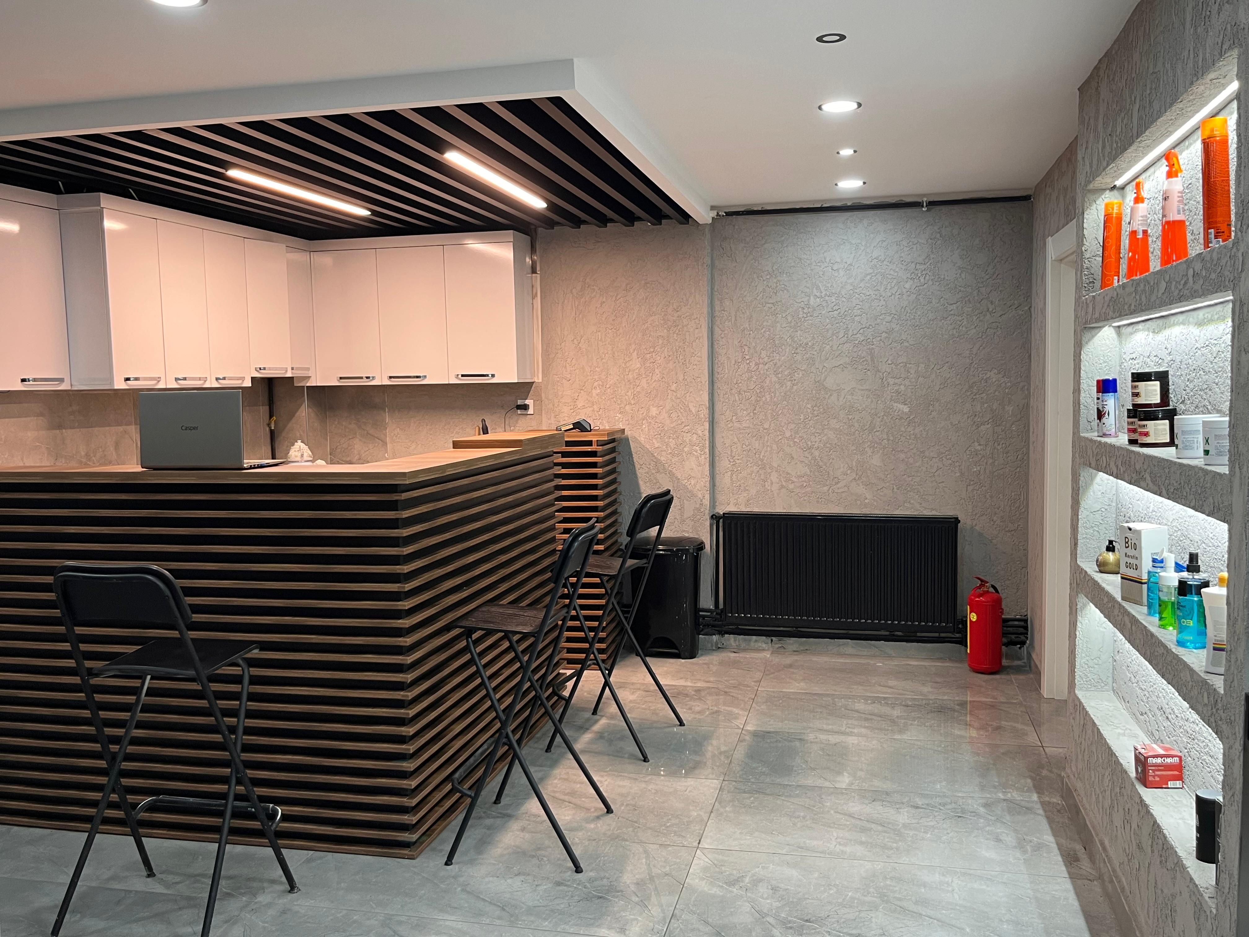 Berber salonu resepsiyon alanı - Sefa Alış Berber. Modern dekorasyon, ürün vitrinleri, LED aydınlatmalı raflar. Ankara'da profesyonel erkek kuaförlük hizmetleri.